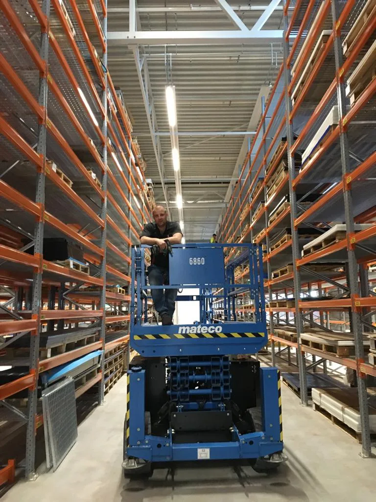 Pracownik na podnośniku w magazynie