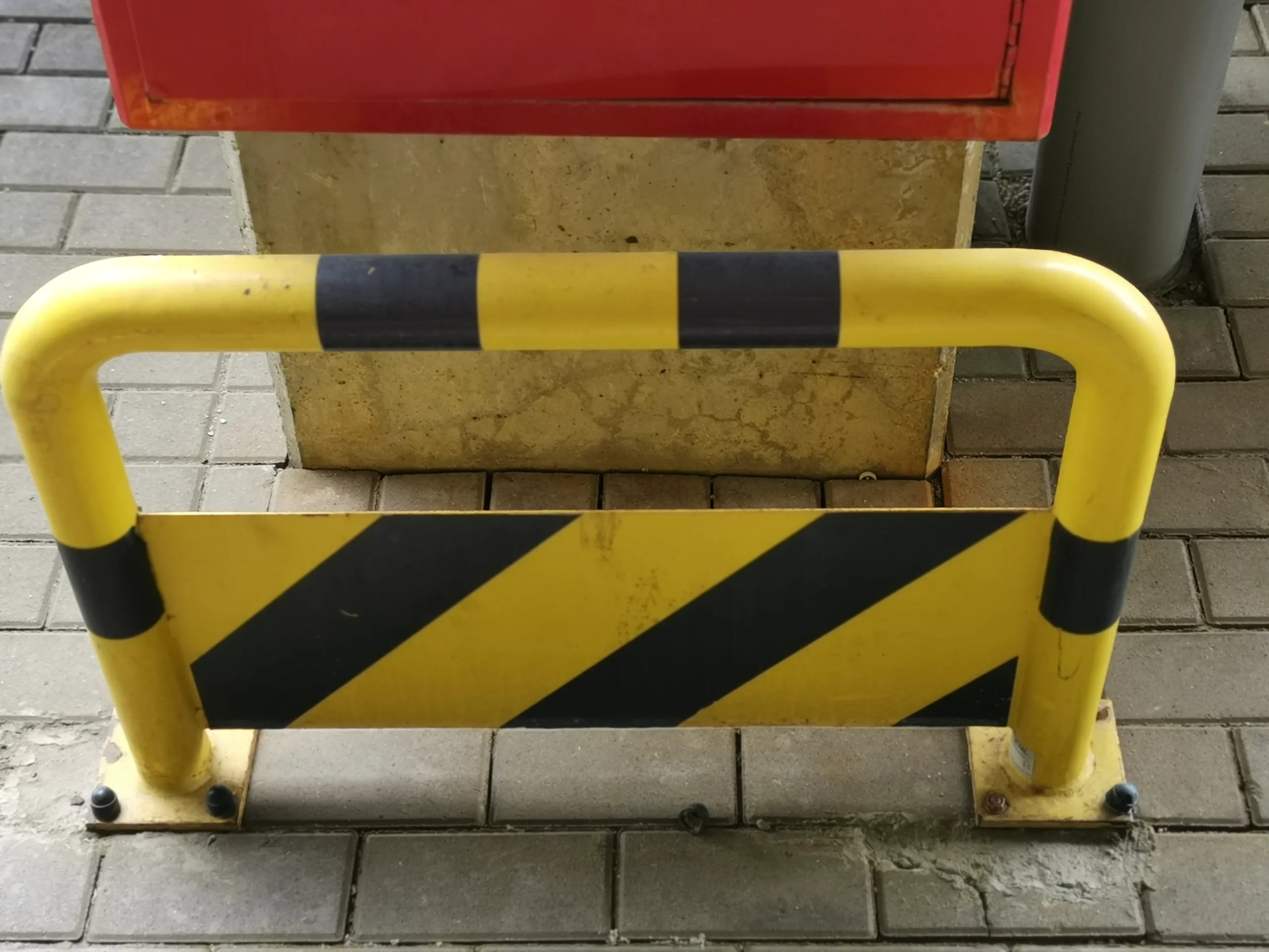 Gele veiligheidsbarrière met zwart-witte strepen ter bescherming van een constructie