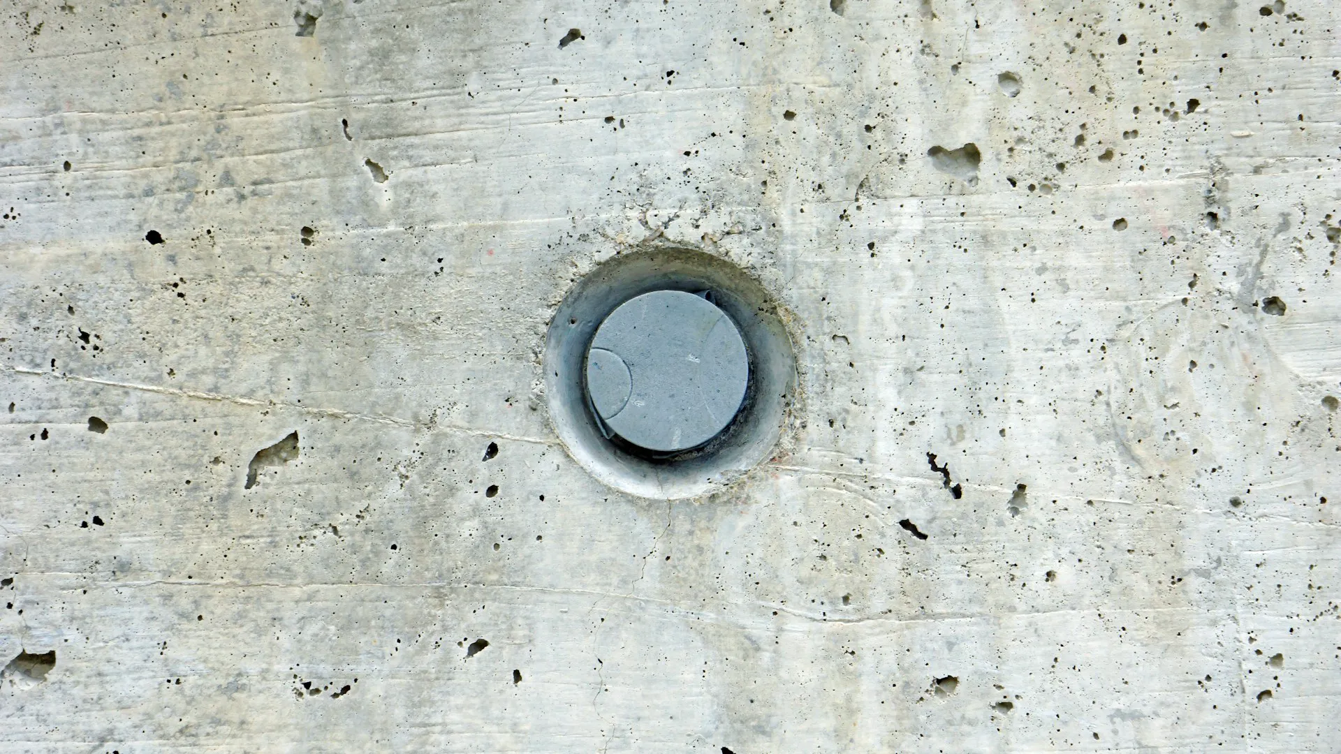 Een betonnen wand met een ronde opening voor kernboringen