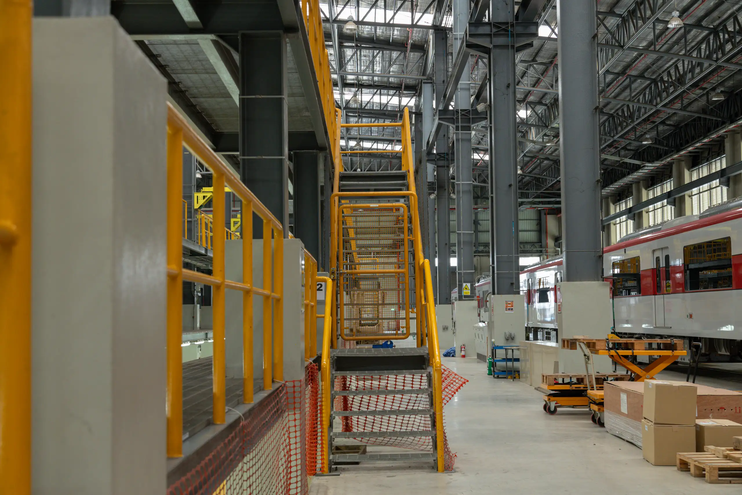 Stalen trappen en leuningen in een industriële omgeving met veiligheidsbarrières