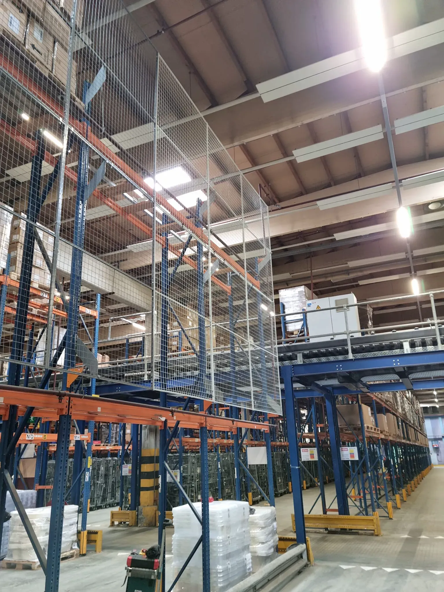 Magazijnstellingen met veiligheidsbarrières in een moderne opslagruimte